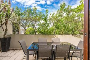 a patio with a table and chairs and trees at Byron Bay Accom Unit 6 21-25 Fletcher Street - A Seventh Heaven in Byron Bay