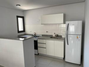 a white kitchen with a refrigerator and a sink at Hermoso dpto. Zona céntrica in Santiago del Estero