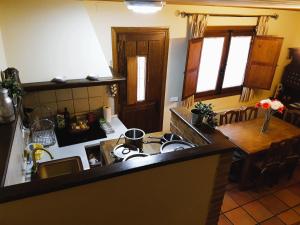a kitchen with a stove and a table in a room at Casa Rural TioMoreno by Naturadrada in La Adrada