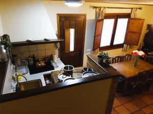 kuchnia z kuchenką i stołem w pokoju w obiekcie Casa Rural TioMoreno by Naturadrada w mieście La Adrada