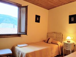 ラ・アドラダにあるCasa Rural TioMoreno by Naturadradaのベッドルーム1室(ベッド2台、窓付)