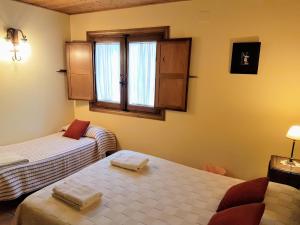 ラ・アドラダにあるCasa Rural TioMoreno by Naturadradaのベッド2台と窓が備わる小さな客室です。