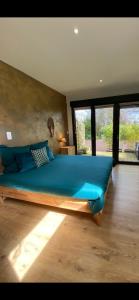 - une chambre avec un grand lit et des oreillers bleus dans l'établissement L'Hôtié de Brocéliande à Paimpont, au coeur des sites naturels et légendaires, à Paimpont