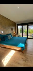una camera da letto con un letto grande con cuscini blu di L'Hôtié de Brocéliande, au coeur des sites naturels et légendaires a Paimpont
