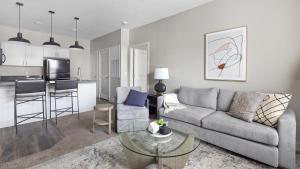 een woonkamer met een bank en een tafel en een keuken bij Landing Modern Apartment with Amazing Amenities (ID8145X4) in Toledo