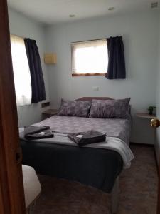 una camera da letto con un letto e due asciugamani di Crossroad Cabins Tooraweenah 
