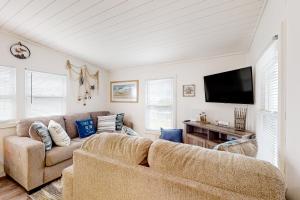 a living room with a couch and a flat screen tv at The Gull's Nest at Isle of Wight in Ocean City