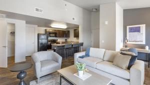 a living room with a couch and chairs and a kitchen at Landing Modern Apartment with Amazing Amenities (ID9601X99) in West Valley City