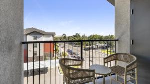 un balcón con 2 sillas y una mesa y un aparcamiento en Landing Modern Apartment with Amazing Amenities (ID9601X99), en West Valley City
