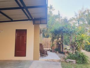 a house with a red door and a patio at Mind's Homestay มายด์โฮมสเตย์ in Kampong Huaibū