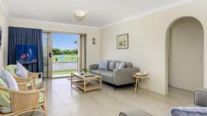 a living room with a couch and a table at Walk to Surf Beach - Ground floor apartment - Bribie Horizons Boyd St, Woorim in Woorim