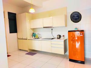 cocina con nevera naranja en una habitación en JB Bukit Indah Skyloft Suites, en Johor Bahru