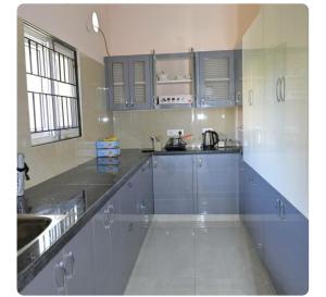 uma grande cozinha com armários azuis e um lavatório em NRI NC Homestays em Tirupati