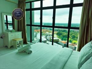 a bedroom with a bed and a large window at JB Bukit Indah Skyloft Suites in Johor Bahru