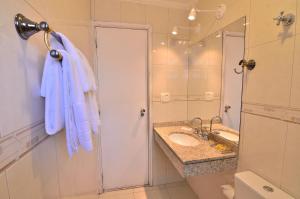 a bathroom with a sink and a shower and a mirror at Hotel Castelar in Sao Paulo