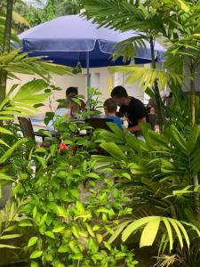 a group of people sitting at a table under an umbrella at Anveela in Beruwala