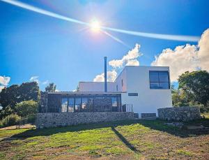a white house with the sun in the sky at Cabaña Syrah en Tapalpa in Tapalpa