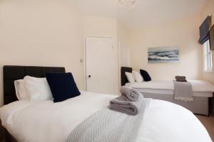- une chambre avec 2 lits et des serviettes dans l'établissement Clarence Cottage, à Whitby