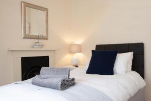 - un lit avec des oreillers bleus et blancs et un miroir dans l'établissement Clarence Cottage, à Whitby