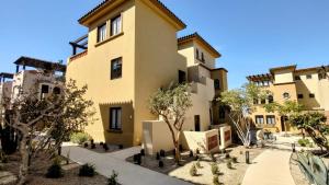 卡波圣卢卡斯Amazing 2BR Pool/Jacuzzi/Beach/ Resort/10Min Cabo的一栋前面有树的公寓楼