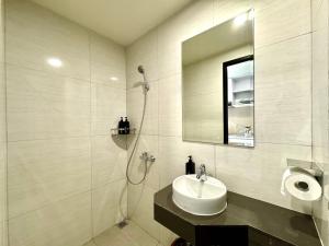 y baño con lavabo y ducha con espejo. en New Stylish Studio Apartment in Central of Nagoya, en Jodoh