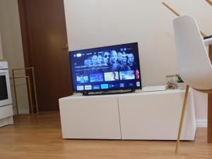 Elle comprend une télévision à écran plat installée au-dessus d'un meuble blanc. dans l'établissement as maison, à Terni