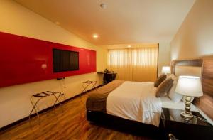 een slaapkamer met een bed en een flatscreen-tv bij HOTEL SHERIDAN BOGOTA in Bogota