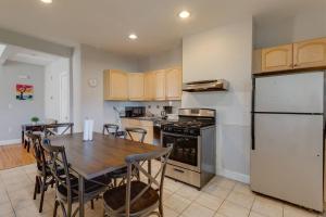 a kitchen with a table and a white refrigerator at NEW! Boston Condo Near MBTA, 3 Mi to Fenway! (U2) in Boston +17 photos