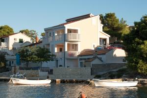 zwei Boote im Wasser vor einem Haus in der Unterkunft Seaside house for families with children Rogoznica - 22156 in Rogoznica + 16 Fotos