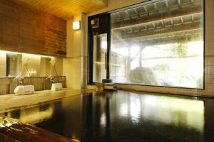 una piscina in bagno con ampia finestra di Matsunoi a Takayama