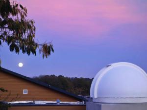 Une lune se levant au-dessus d'une maison avec un observatoire dans l'établissement Gîte Origne, 3 pièces, 4 personnes - FR-1-600-138, 