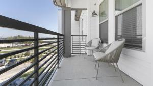 einen Balkon mit 2 Stühlen und Blick auf ein Auto in der Unterkunft Landing Modern Apartment with Amazing Amenities (ID2101X18) in Fort Worth
