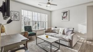 ein Wohnzimmer mit einem Sofa und einem Tisch in der Unterkunft Landing Modern Apartment with Amazing Amenities (ID4420X29) in Richmond