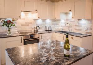 a kitchen with a bottle of wine and two wine glasses at Bridge End Farm Cottages in Boot