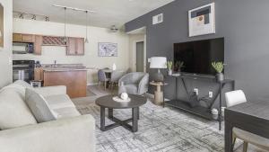 a living room with a couch and a tv and a table at Landing Modern Apartment with Amazing Amenities (ID1174X415) in Madison