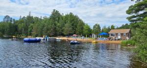 um grupo de pessoas de pé na margem de um lago em Parkway Cottage Resort and Trading Post em Dwight