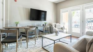 uma sala de estar com um sofá e mesas e uma televisão em Landing Modern Apartment with Amazing Amenities (ID5789X48) em El Paso