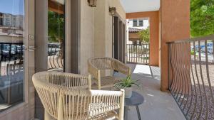 um alpendre com duas cadeiras de vime e uma mesa em Landing Modern Apartment with Amazing Amenities (ID5789X48) em El Paso