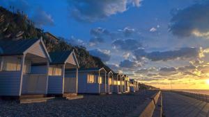 a row of beach huts on the beach at sunset at Double room minutes from the beach in Bexhill