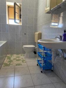 La salle de bains est pourvue d'un lavabo et de toilettes. dans l'établissement Apartments with a parking space Crikvenica - 22214, à Crikvenica