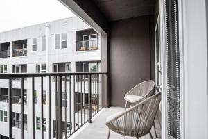 a balcony with two chairs and a building at Landing Modern Apartment with Amazing Amenities (ID5034X58) in Tower Grove