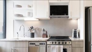 a kitchen with white cabinets and a stove top oven at Landing Modern Apartment with Amazing Amenities (ID1228X660) in Cambridge