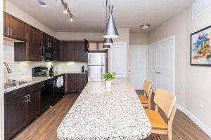 cocina con mesa y sillas en una habitación en Landing Modern Apartment with Amazing Amenities (ID3883), en Carrollton