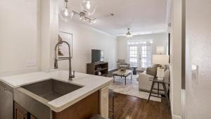 eine Küche mit einem Waschbecken und ein Wohnzimmer in der Unterkunft Landing Modern Apartment with Amazing Amenities (ID6447X41) in Houston