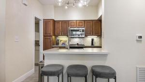 eine Küche mit einer Theke mit drei Stühlen in der Unterkunft Landing Modern Apartment with Amazing Amenities (ID6447X41) in Houston