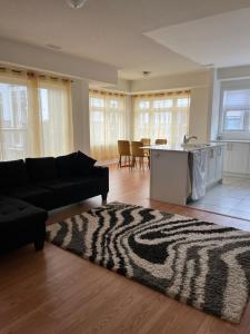 a living room with a black couch and a zebra rug at Luxury Brand New Townhouse In Milton Ontario in Milton