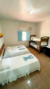 a hotel room with two beds and a chair at Recanto das Estrelas in Marau