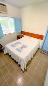a bedroom with a white bed with blue shutters at Recanto das Estrelas in Marau
