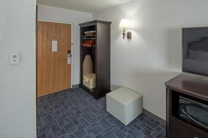 Habitación con puerta, taburete y TV. en Holland Hotel Free Parking Jersey City, en Jersey City