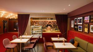 un restaurante con mesas y sillas y un hombre detrás del mostrador en Hotel Indigo Sydney Potts Point, an IHG Hotel en Sídney